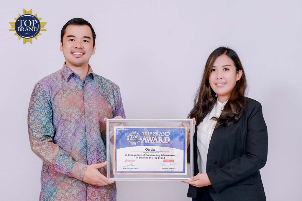 Direktur Frontier Fandy Santoso memberikan penghargaan Top Brand langsung kepada Karen Wulandari, Marketing Manager ONDA di Hotel Mulia Jakarta, Selasa (19/04/2022).